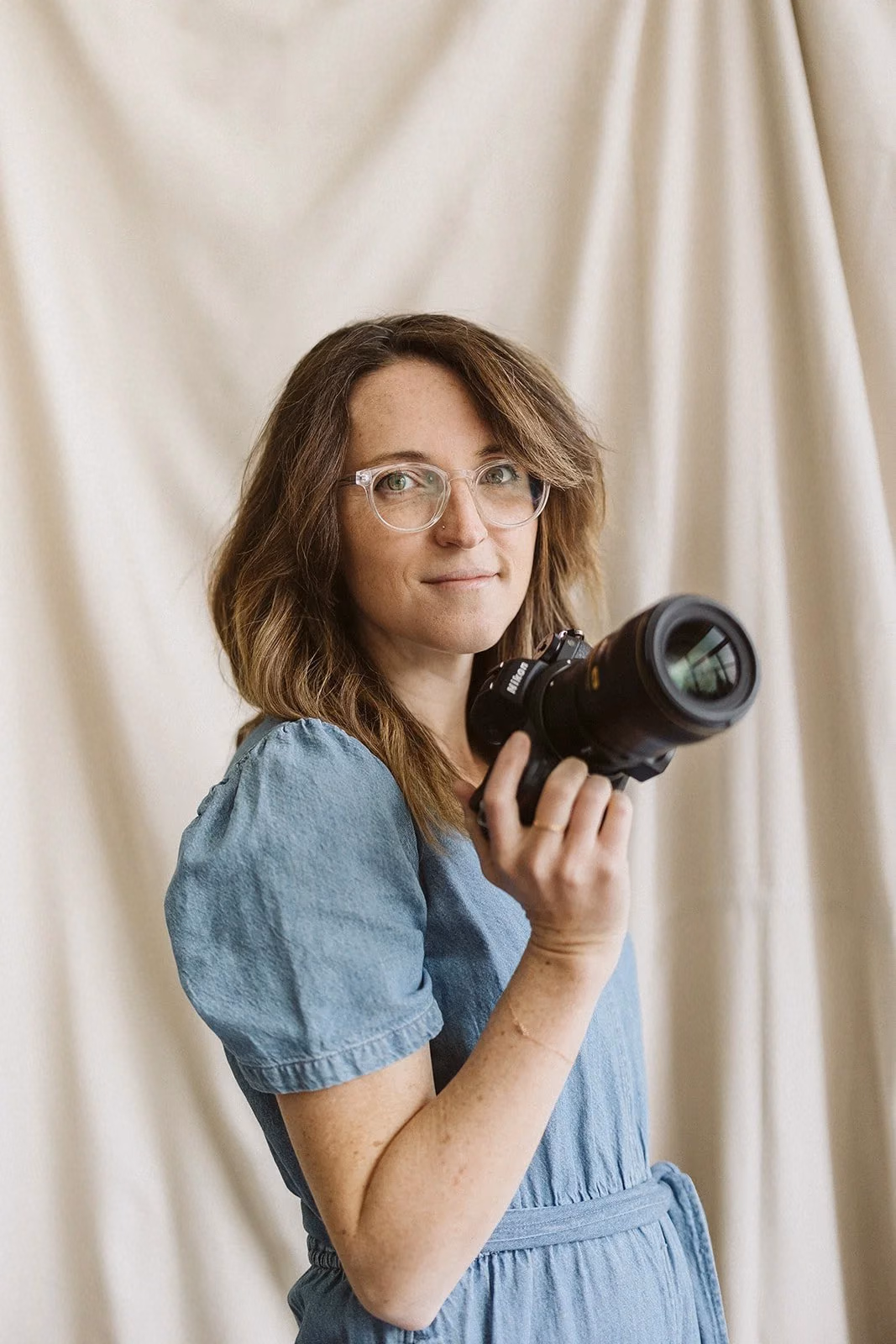 Alice Rouse, Boston and North Shore photographer, holding her camera